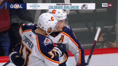 Hockey Players Hugging In Front Of Avalanche Ad GIF