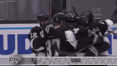 Hockey Players Hugging In Front Of Kings Ad GIF