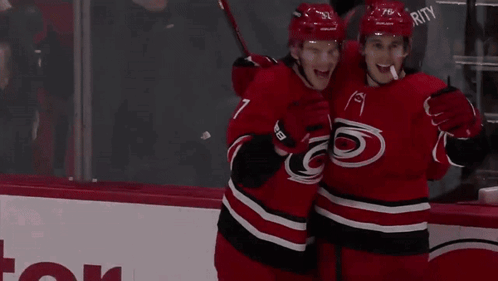 Hockey Players In Red And Black Uniforms GIF