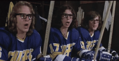 Hockey Players Sitting In Locker Room With Sticks GIF