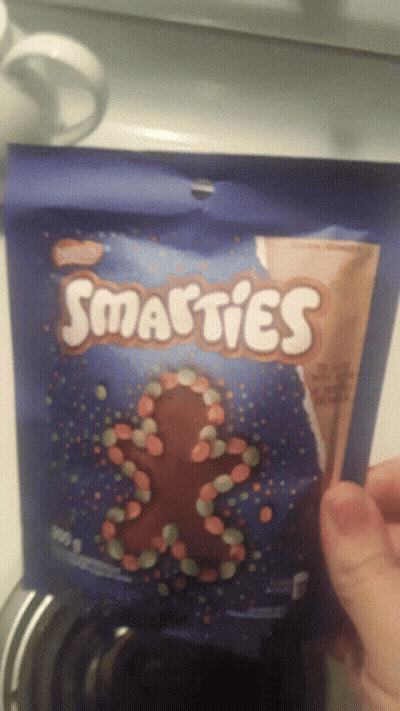 Holding Bag Of Smarties Candy GIF