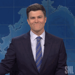 Holding In Laugh Colin Jost As Newscaster GIF