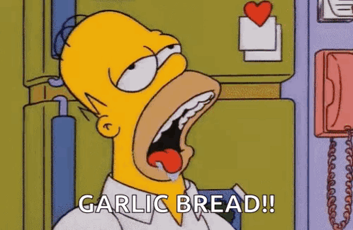 Homer Simpson From The Simpsons Is Eating Garlic Bread With His Mouth Open . GIF