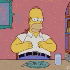 Homer Simpson From The Simpsons Is Sitting At A Table With A Plate And A Glass Of Water GIF