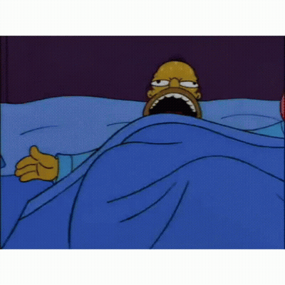 Homer Simpson Is Laying In A Bed With His Mouth Open . GIF