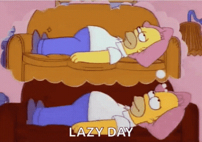 Homer Simpson Is Laying On A Couch With A Pink Pillow On His Head . GIF