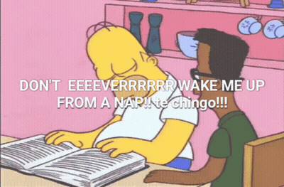 Homer Simpson Is Sitting At A Table Reading A Book While Another Man Looks On GIF