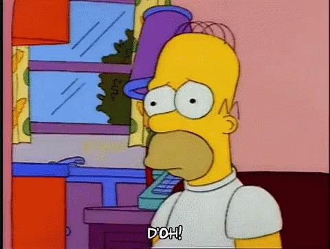 Homer Simpson Is Standing In Front Of A Window With A Bucket On His Head . GIF