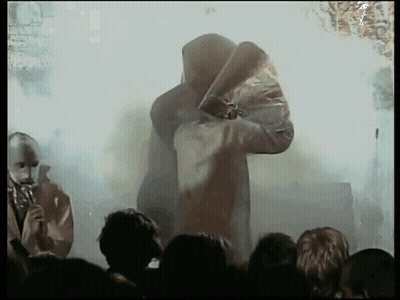 Hooded Man Holding Sword Before Crowd GIF