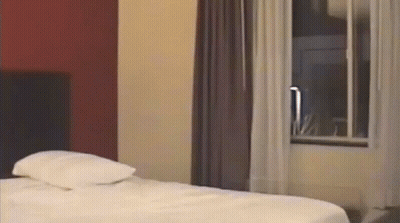 Hotel Room With Bed And Curtained Window GIF