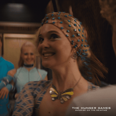Hunger Games Poster Woman Smiling Butterfly Necklace GIF