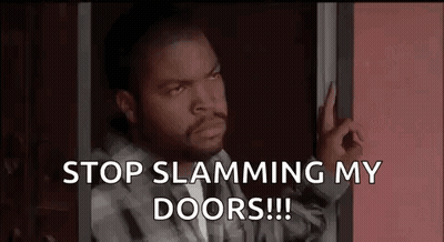 Ice Cube Is Standing In A Doorway With His Hand On The Door . GIF