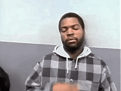 Ice Cube Is Wearing A Plaid Shirt And A Hoodie While Standing In Front Of A Wall . GIF