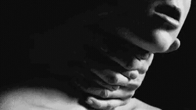 It Is A Black And White Photo Of A Woman Holding Her Neck . GIF