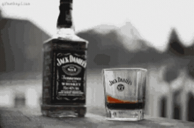 Jack Daniel's Whiskey Next To Shot Glass GIF
