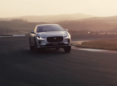Jaguar Car Driving On Road With Mountains GIF