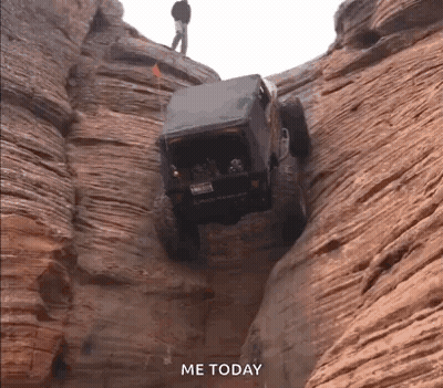 Jeep Driving Down Canyon With Man Standing On Top GIF