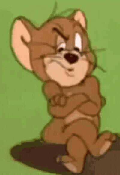 Jerry From Tom And Jerry Is Sitting On A Rock With His Arms Crossed And Looking Angry . GIF