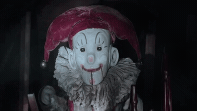 Jester Statue With Bloody Mouth Sitting In Chair GIF