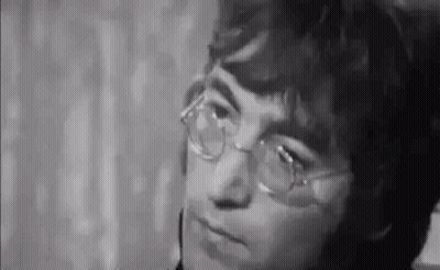 John Lennon Making Funny Face In Suit And Tie GIF