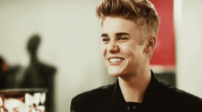 Justin Bieber Is Smiling And Looking At The Camera In A Black Jacket . GIF
