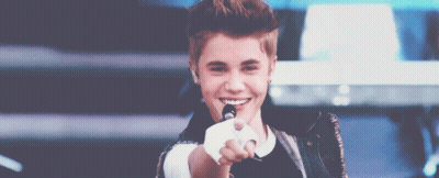 Justin Bieber Is Smiling And Pointing At The Camera While Holding A Microphone GIF