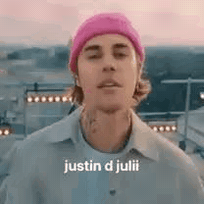 Justin D Julii Is Wearing A Pink Beanie And A White Shirt . GIF