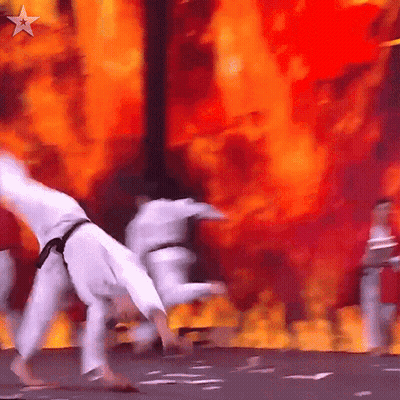 Karate Fighters Performing On Stage With Fire GIF