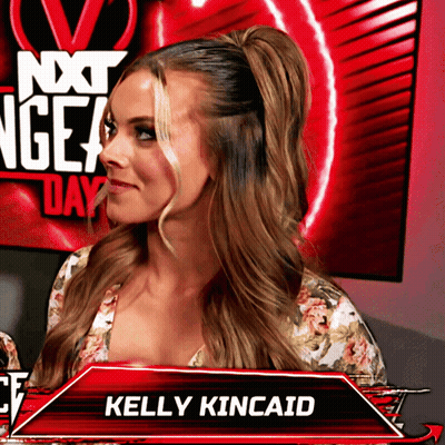 Kelly Kincaid Standing Before Red Next Gen Day Sign GIF