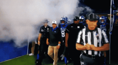 Kentucky Football Players Are Walking On The Field With Smoke Coming Out Of The Tunnel GIF