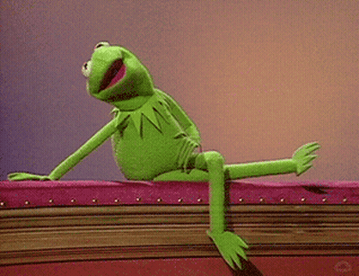 Kermit The Frog From Sesame Street Is Sitting On A Pink Couch . GIF