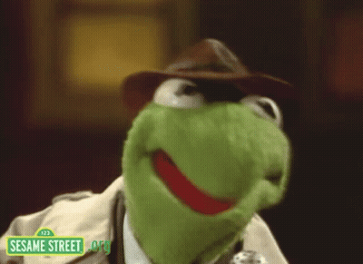 Kermit The Frog From Sesame Street Wearing A Hat And A Trench Coat GIF