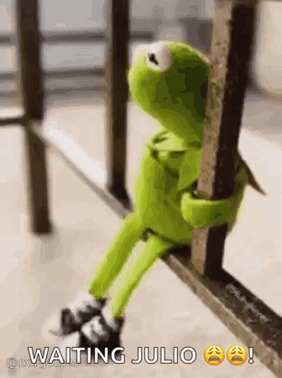 Kermit The Frog Is Sitting On A Railing Holding Onto A Pole . GIF