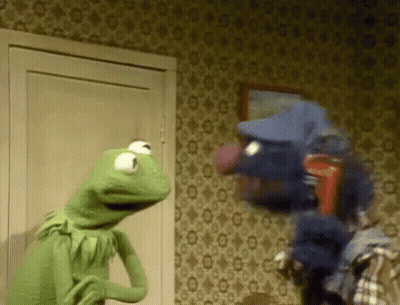 Kermit The Frog Is Standing Next To A Puppet In A Room . GIF