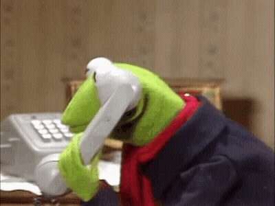 Kermit The Frog Is Talking On A Telephone While Sitting At A Desk . GIF