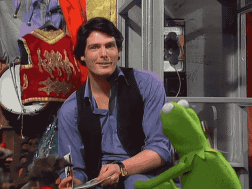 Kermit The Frog Sits Next To A Man In A Purple Shirt GIF