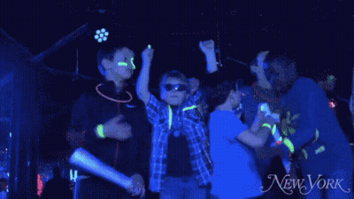 Kids Dancing With Glow Sticks In Front Of New York Ad GIF