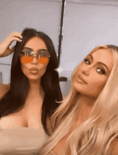 Kim Kardashian And Paris Hilton Are Posing For A Picture Together While Wearing Sunglasses . GIF