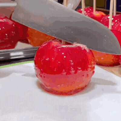 Knife Cutting Red Apple On A Stick GIF