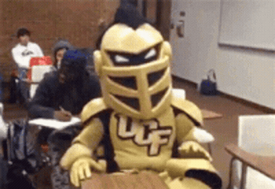 Knight Mascot Sitting At Desk In Classroom GIF