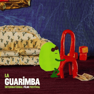 La Guarimba International Film Festival Green Character Sitting On Red Chair GIF