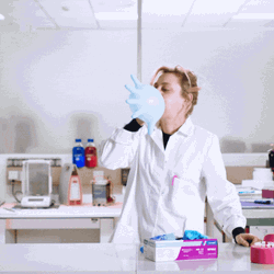 Laboratory Nurse Blowing Balloon