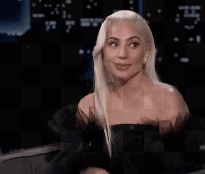 Lady Gaga Sitting In Chair With Hands In Air GIF
