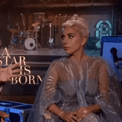 Lady Gaga Sitting In Front Of A Star Is Born Sign GIF