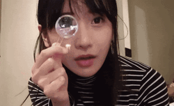 Lady Using Small Magnifying Glass GIF