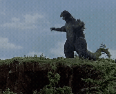 Large Black Dinosaur Standing On Hill GIF