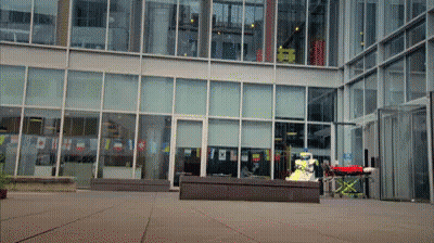 Large Building With Red Ambulance Parked Out Front GIF
