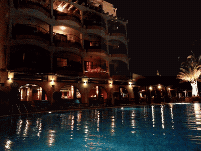 Large Building With Swimming Pool At Night GIF