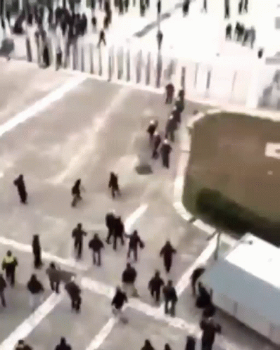 Large Group Walking Down City Street GIF