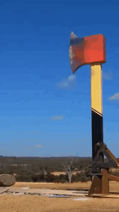 Large Red Yellow And Black Axe In Field GIF